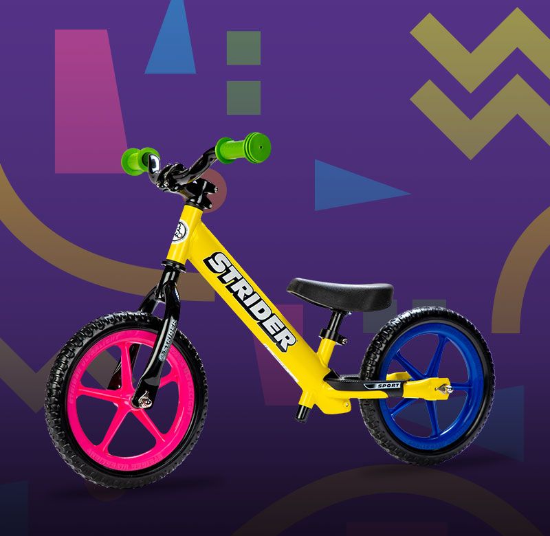 Studio image of yellow 12 Sport with aluminum riser bars and green grips, pink front wheel, and blue rear wheel