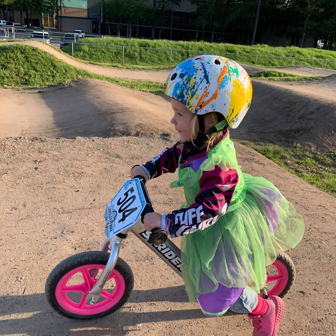 Girl in a princess dress runs on her Strider Bike