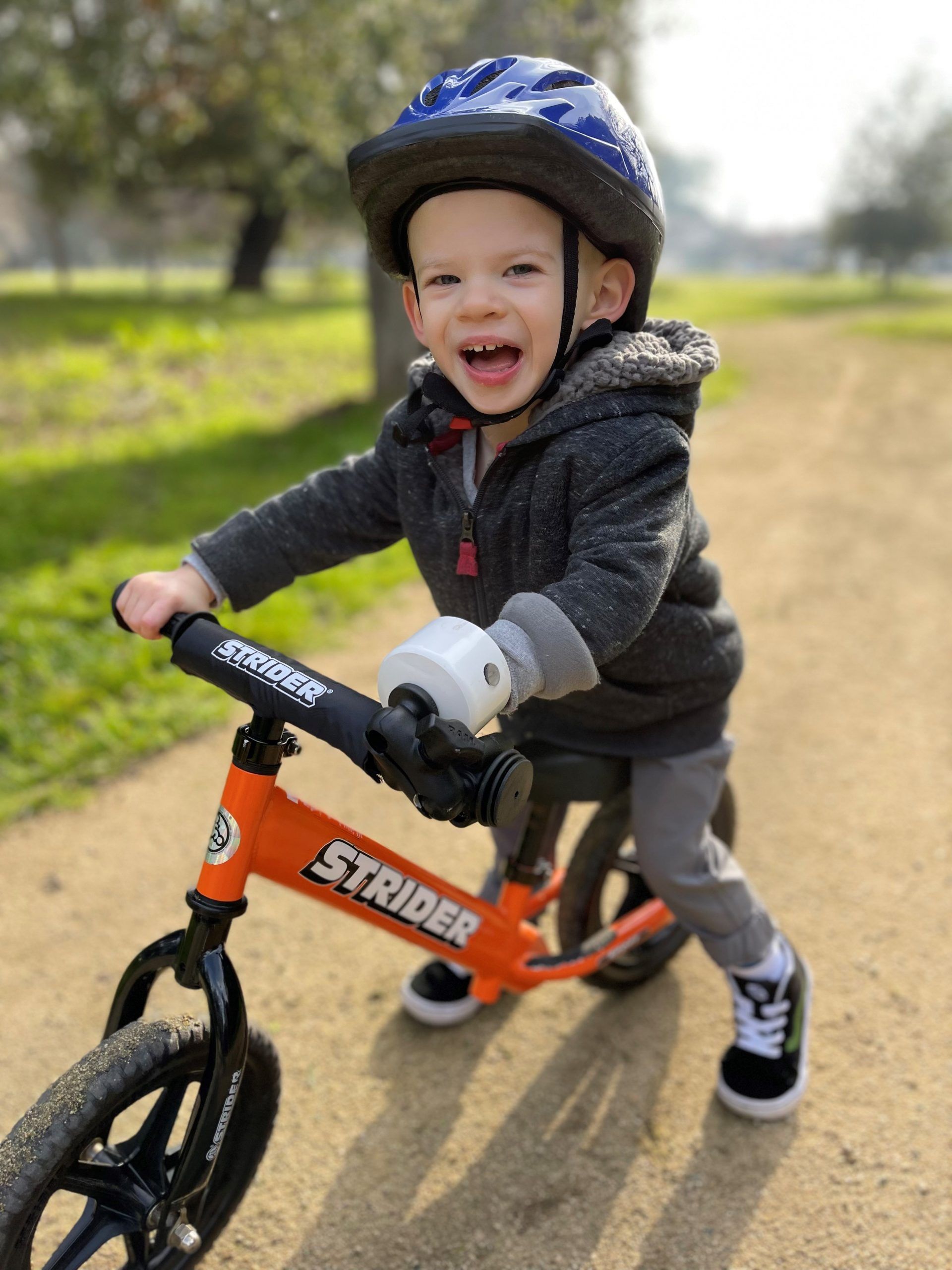 Ryder Morgan smiles as he rides his adaptive Strider 12 Sport