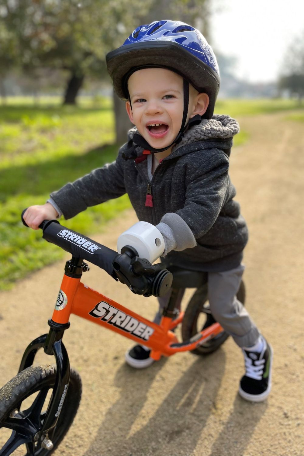 Ryder Morgan smiles as he rides his adaptive Strider 12 Sport