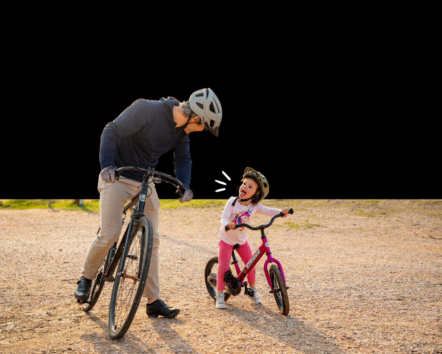 Young girl on Strider 14x sticks her tongue out at her dad