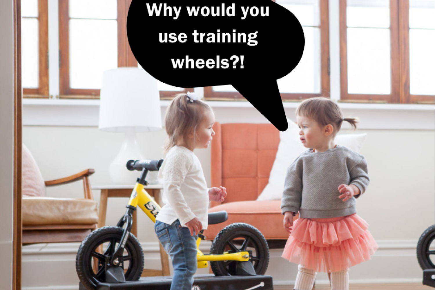 two girls stand by a Strider Rocking Bike with a voice bubble saying Why would you use training wheels?