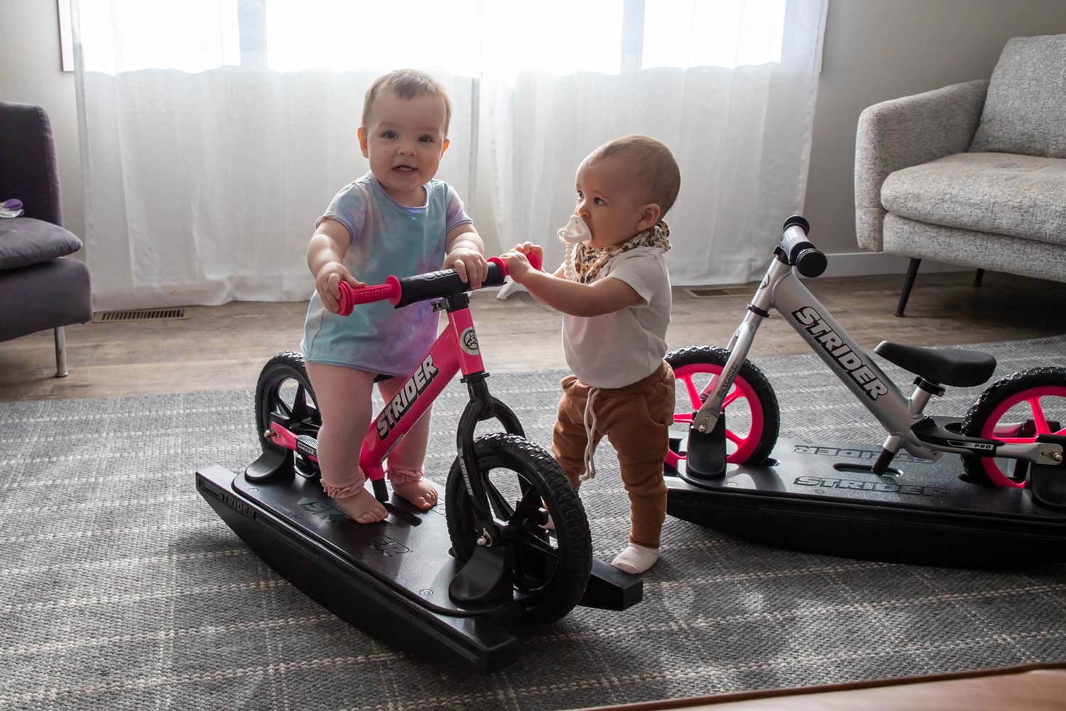 Two babies play on Strider Rocking Bikes