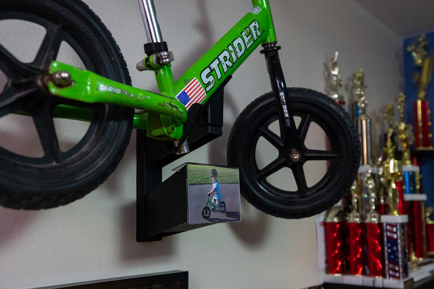 Close up of a Strider Bike in a Memory Mount attached to a bedroom wall