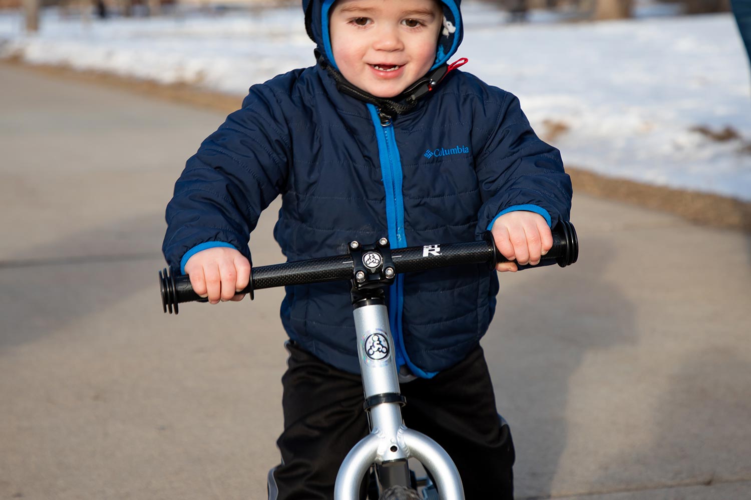 A young boy in a blue coat on a bike with an ST-R carbon fiber handlebar